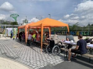 Lange Tafel, an der Menschen sitzen und essen