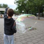 Mädchen macht Seifenblasen auf einem Pausenhof