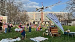 Im Vordergrund Fröhliches Treiben, im Hintergrund die Baustelle für ein neues Stadtteilhaus