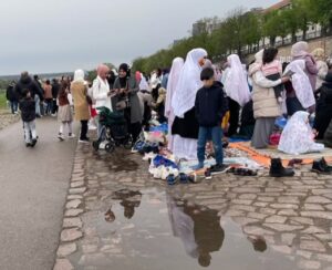 Frauen mit Kopftuch und Kinder hinter einer Pfütze