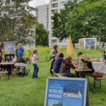 Besucher sitzen auf den Bänken und unterhalten sich.