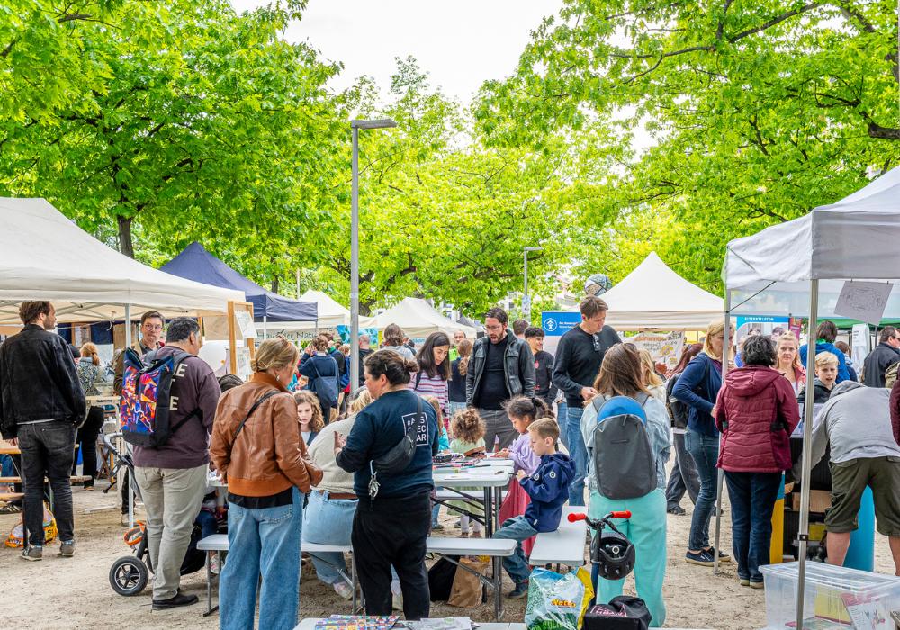 Menschen auf einem Festgelände zwiscehn Pavillions