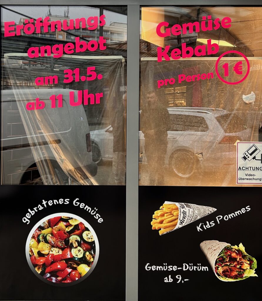 Schaufenster, beklebt mit Eröffnungsangebot am 31.5. Gemüsekebab ab 1€