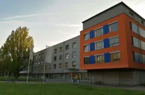 Ein Bild, das Gebäude, Himmel, Wolke, Baum, Gras enthält.