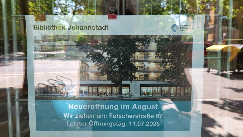 Schaufenster der Bibliothek mit einem Aushang zur Neueröffnung an einem anderen Ort.