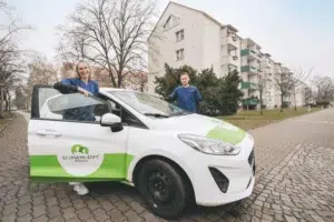 Eine Frau und ein Mann stehen an einem Auto.