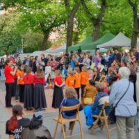 Besucher*innen des Bönischplatzfestes 2025 schauen Kindern bei ihrem Auftritt zu