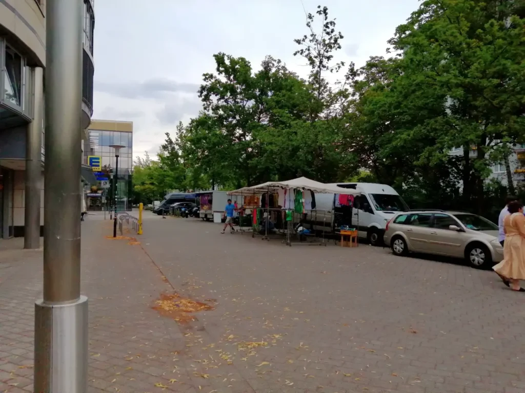 Ein kleiner Platz zwischen Gebäuden mit Marktständen.