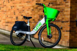 Elektrofahrrad in weiß-grüner Optik steht an einer Ziegelwand.